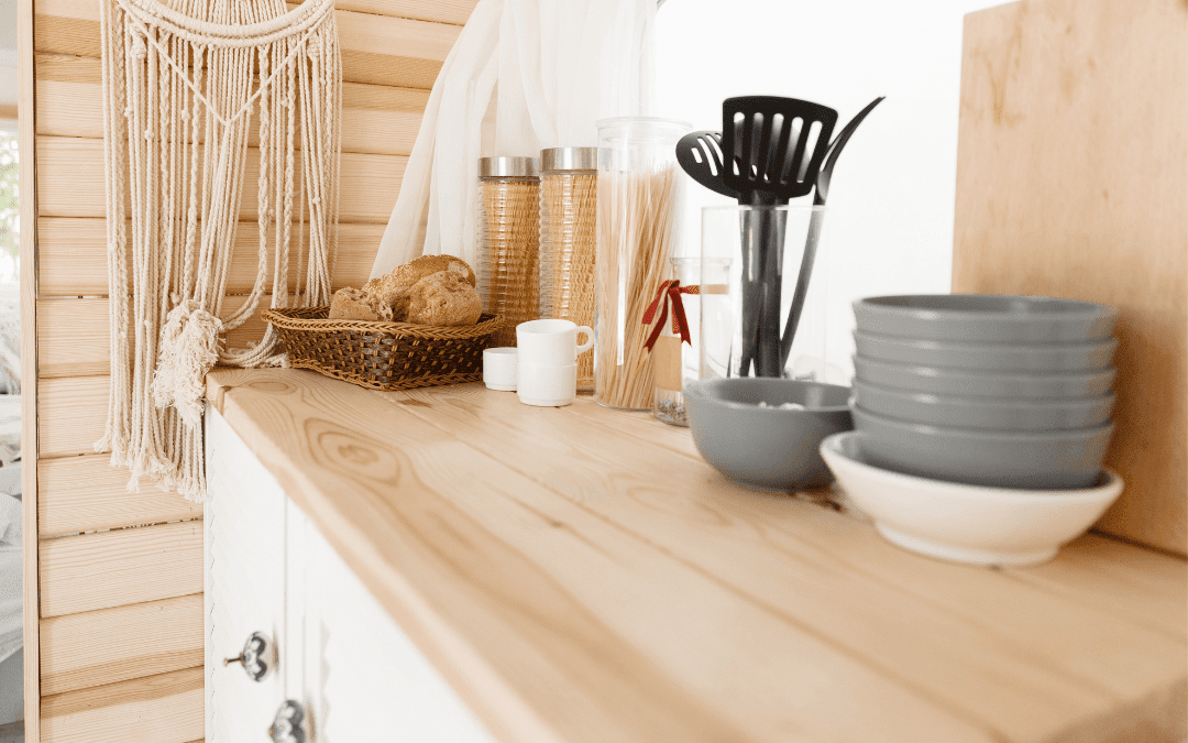 Cozy modern RV interior with wooden counter, macrame wall hanging, and warm natural decor after custom renovation