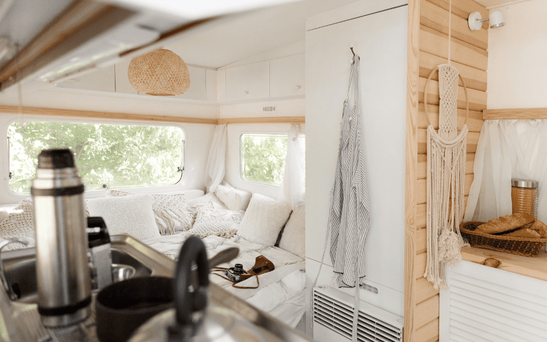 Cozy renovated RV interior with wood paneling, macrame wall hanging, and modern living space after custom renovation