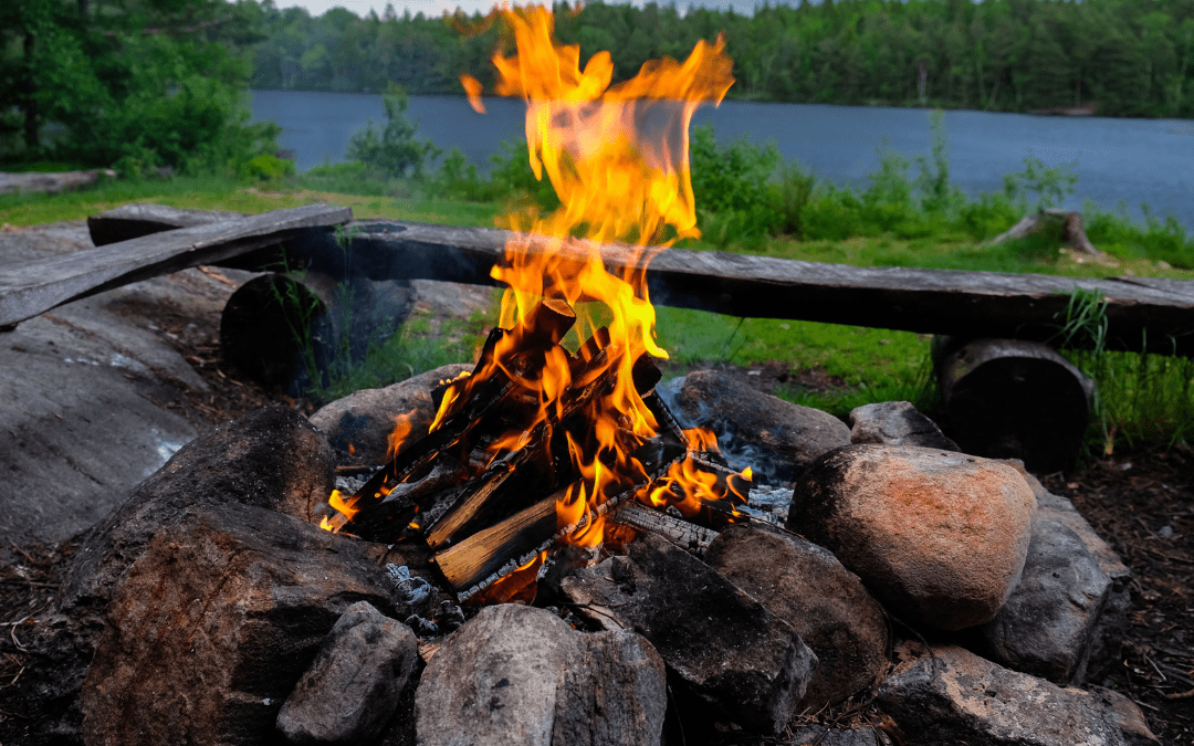 Crackling campfire built with a simple DIY fire pit on the lakeshore, perfect budget-friendly RV camping upgrade