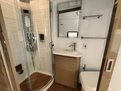 Luxury bathroom inside The Beast custom RV build featuring shower, sink, and toilet by Ace of Spades Custom RV and Repair Las Vegas