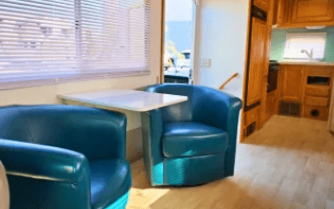 Renovated RV dinette with teal chairs and wood cabinets after professional repair in Las Vegas by Ace of Spades